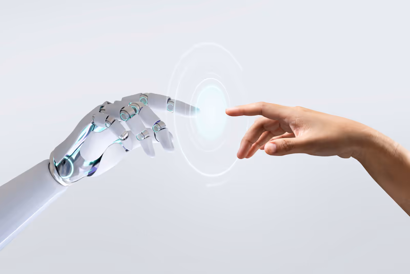 Een robothand en een mensenhand die elkaar bijna raken: mens en AI komen samen.